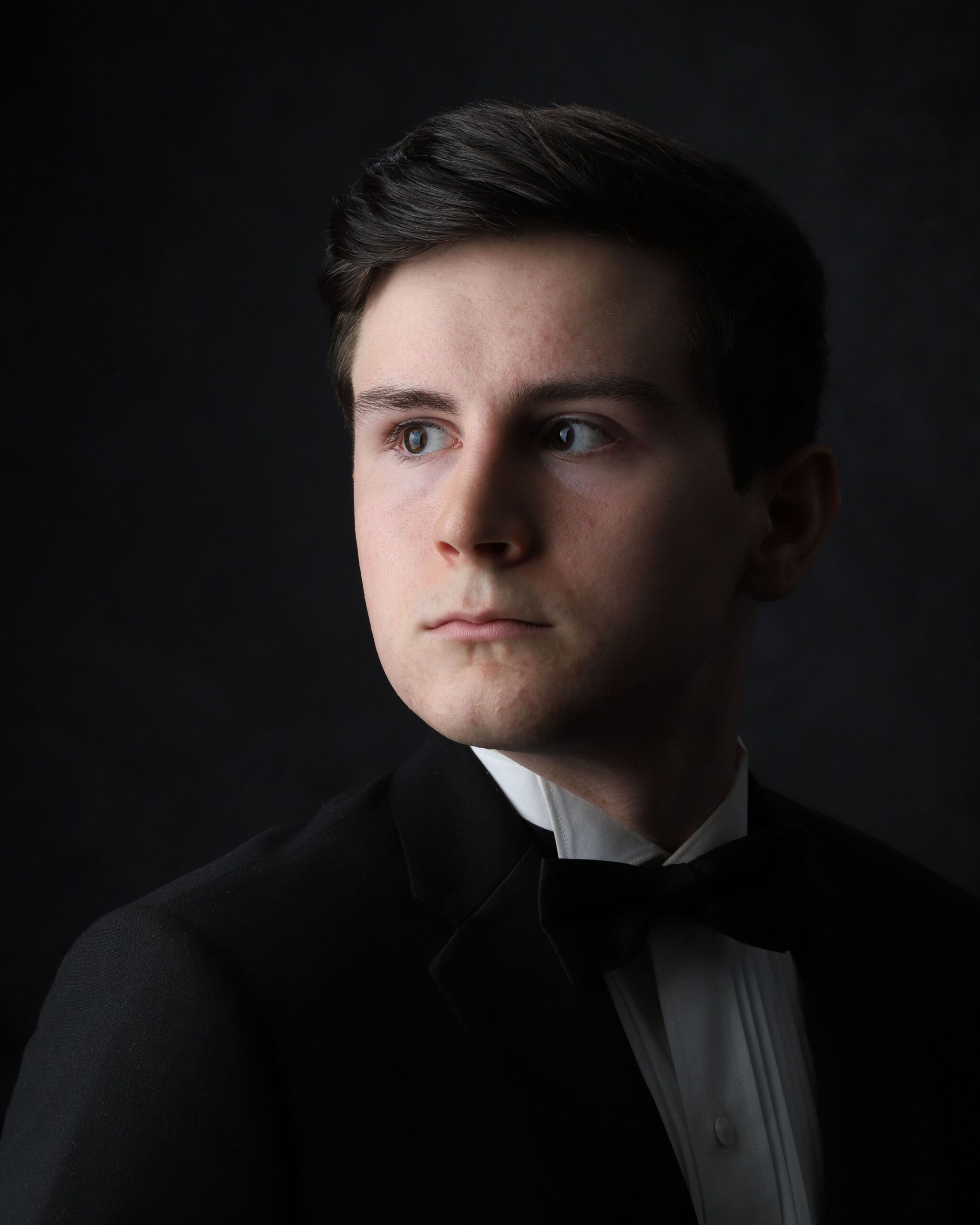 Head shot of Brandon Antonio Adams in a black suit jacket, white shirt, and a black necktie.